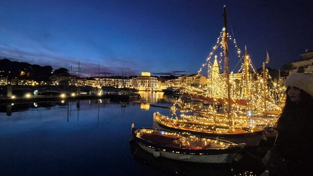 A boat adorned with lights docked at a marina with buildings in the background. - 50 steps from the Ô (Saint-Cyr-sur-Mer)