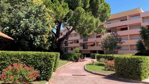A building with a central tree, surrounded by well-maintained hedges and flower beds. - 50 steps from the Ô (Saint-Cyr-sur-Mer)