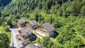 Ein mehrstöckiges Hotel mit Balkonen, umgeben von dichtem Wald.