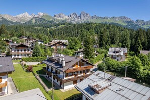 Un barrio residencial con casas, cielo despejado y montañas al fondo.