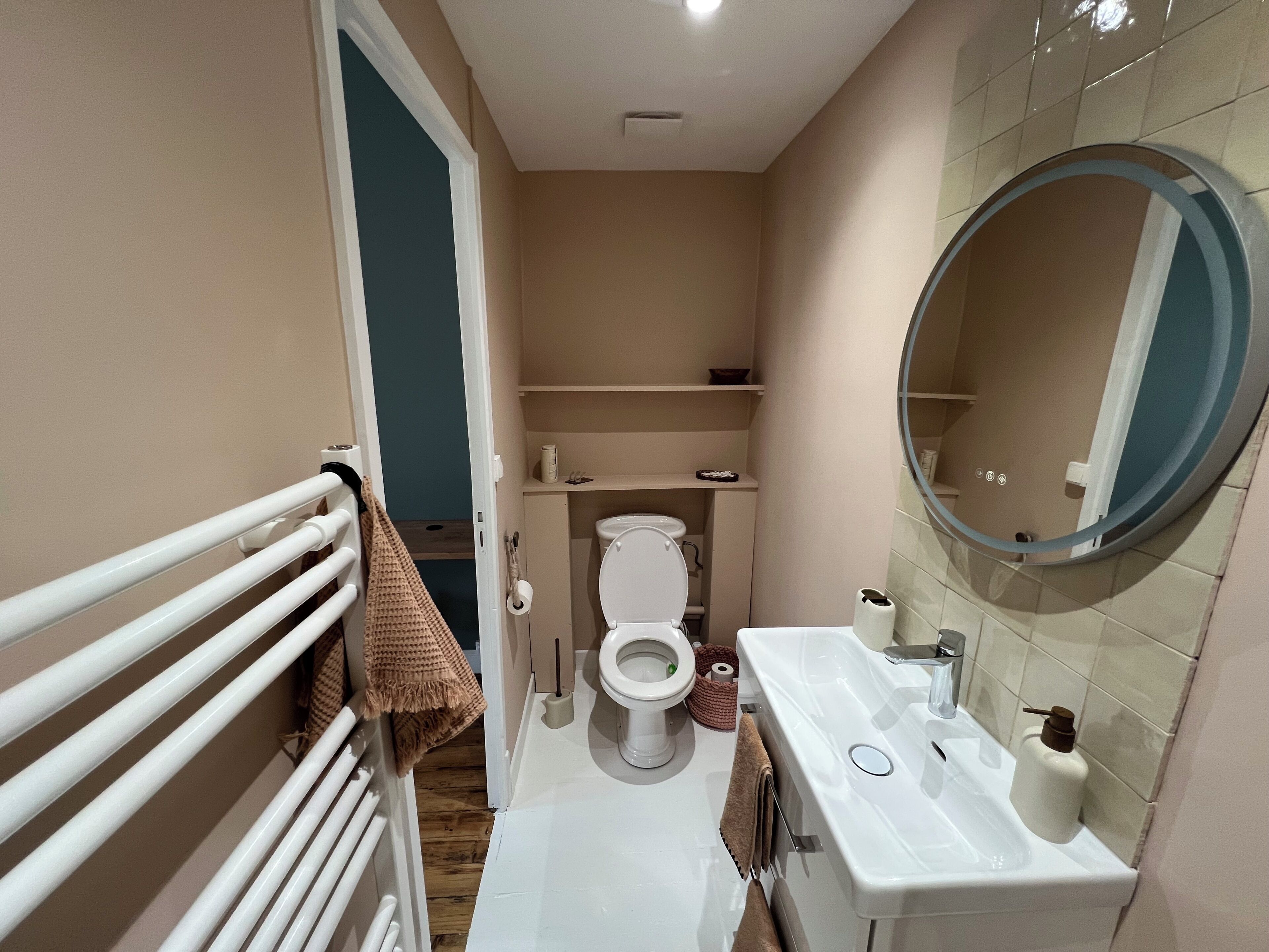 Une petite salle de bain comprenant des toilettes, un lavabo et un miroir.