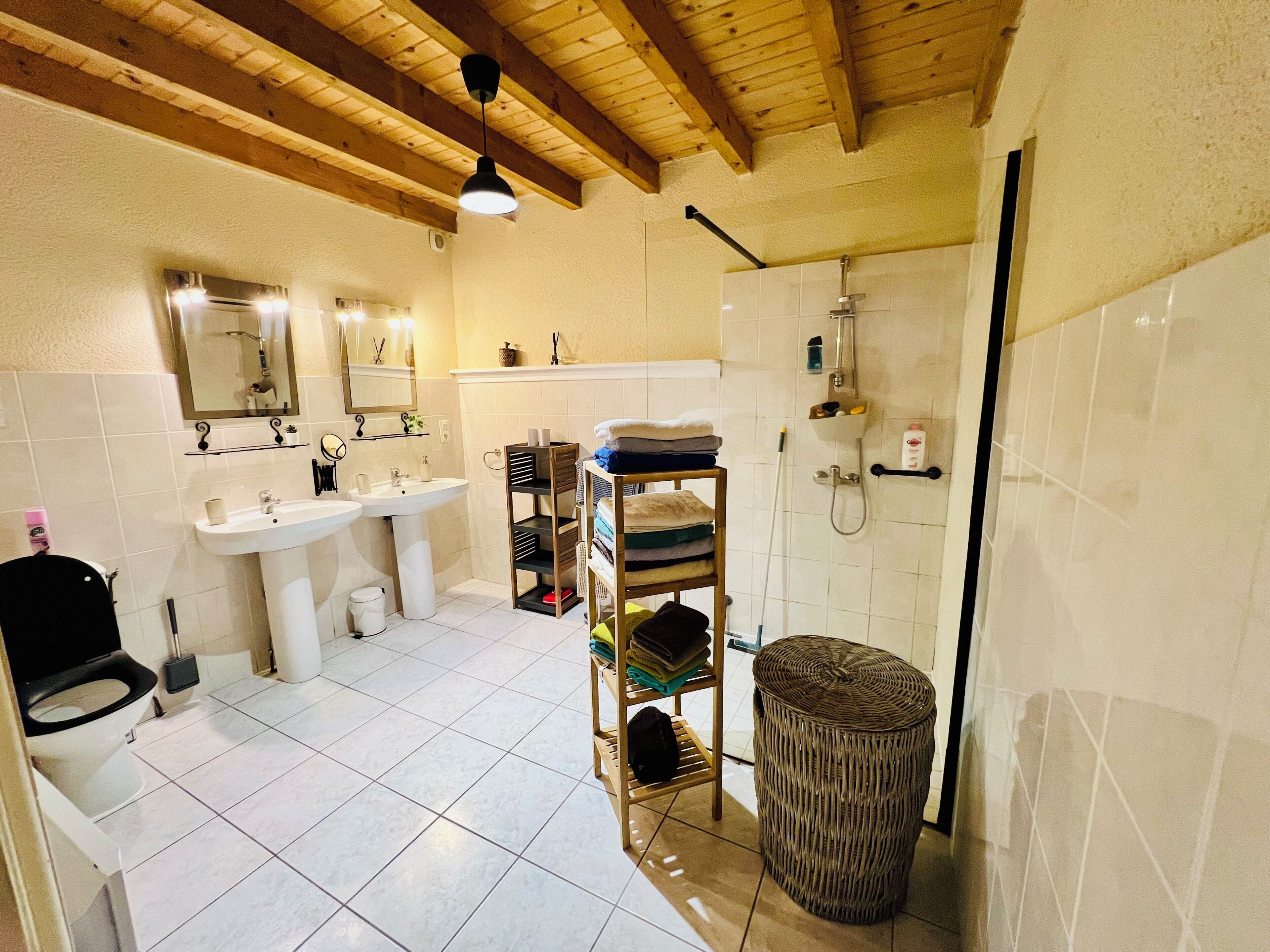 Un baño con inodoro, lavamanos, espejo y ducha.