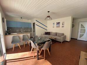Un espace de vie compact comprenant un coin repas, une cuisine et un canapé.