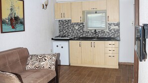 Una cocina compacta con armarios de madera, una estufa empotrada y una ventana sobre el fregadero.
