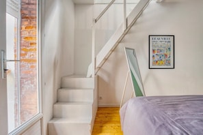 A bedroom with a bed, a window, a staircase, and a poster on the wall. - Hyper-center - Beach on foot - Cosy accommodation (Villers-sur-Mer)