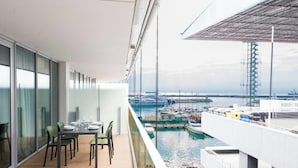 A balcony with a dining table and chairs, overlooking a marina with boats and a bridge. - Waterfront Lux| Studio|A/C|Parking Wifi By Tilo (Genoa)