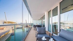 Un balcone con vista su un canale, un tavolo con sedie e un divano.