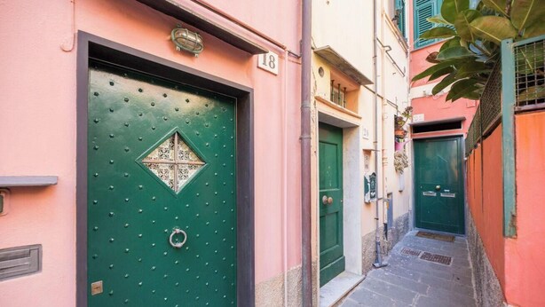 A narrow alleyway with a green door marked '18' and a smaller door next to it. - Bocadasse Beach| Parking| Wifi| By Tilo (Genoa)