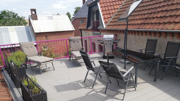 A rooftop patio with outdoor furniture, a grill, and a view of the neighborhood. - Quiet apartment with very large roof terrace (Wittenburg)