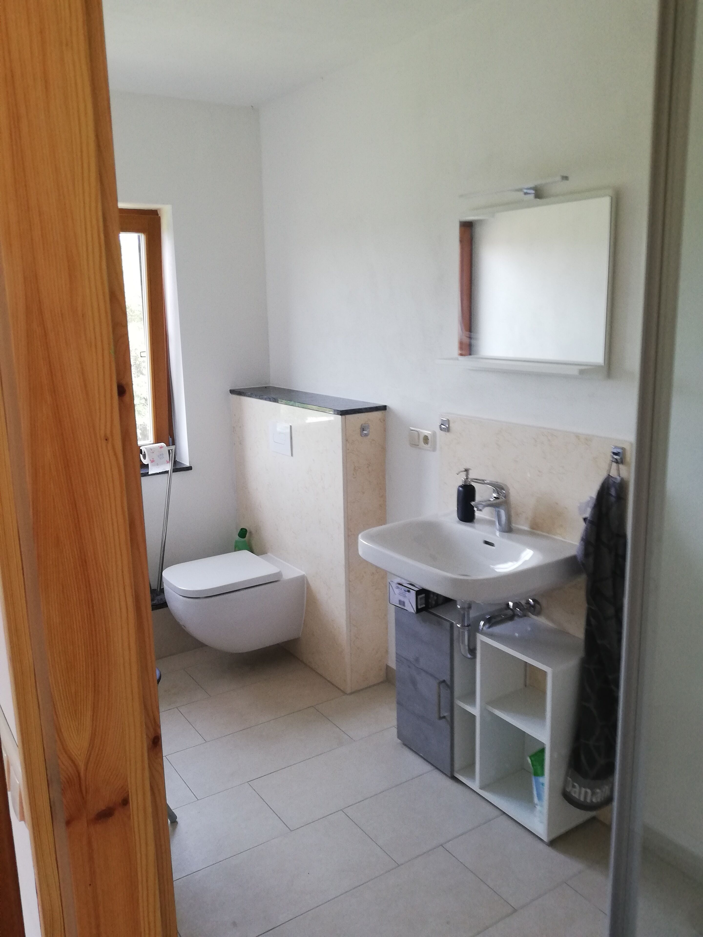 Une petite salle de bain avec des toilettes, un lavabo et un meuble de rangement.