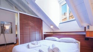 A hotel room with a bed, a window, and a wooden headboard. - Aquarium 5'| 1BR | A/C| By Tilo (Genoa)