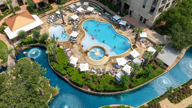 Un complex turístic amb diverses piscines, zones de relaxació i un jardí paisatjístic.