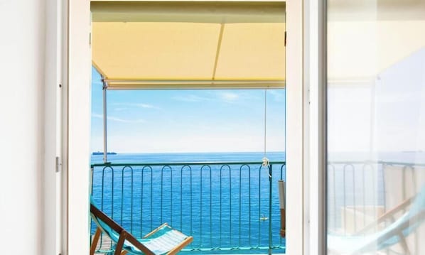 A balcony with a view of the sea, a chair, and a table. - “Vista Mare Genova”A two-level gem with a spectacular sea view, unique in the area.Lower floor: Bedroom with premium-quality mattress, bathroom, and a cozy corner with table and chess set overlooking the sea.Upper floor: Living room with sofa bed, fu (genova)