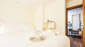 A hotel room with a neatly made bed, a small shelf with a lamp, and a view of the hallway. - “Vista Mare Genova”A two-level gem with a spectacular sea view, unique in the area.Lower floor: Bedroom with premium-quality mattress, bathroom, and a cozy corner with table and chess set overlooking the sea.Upper floor: Living room with sofa bed, fu (genova)