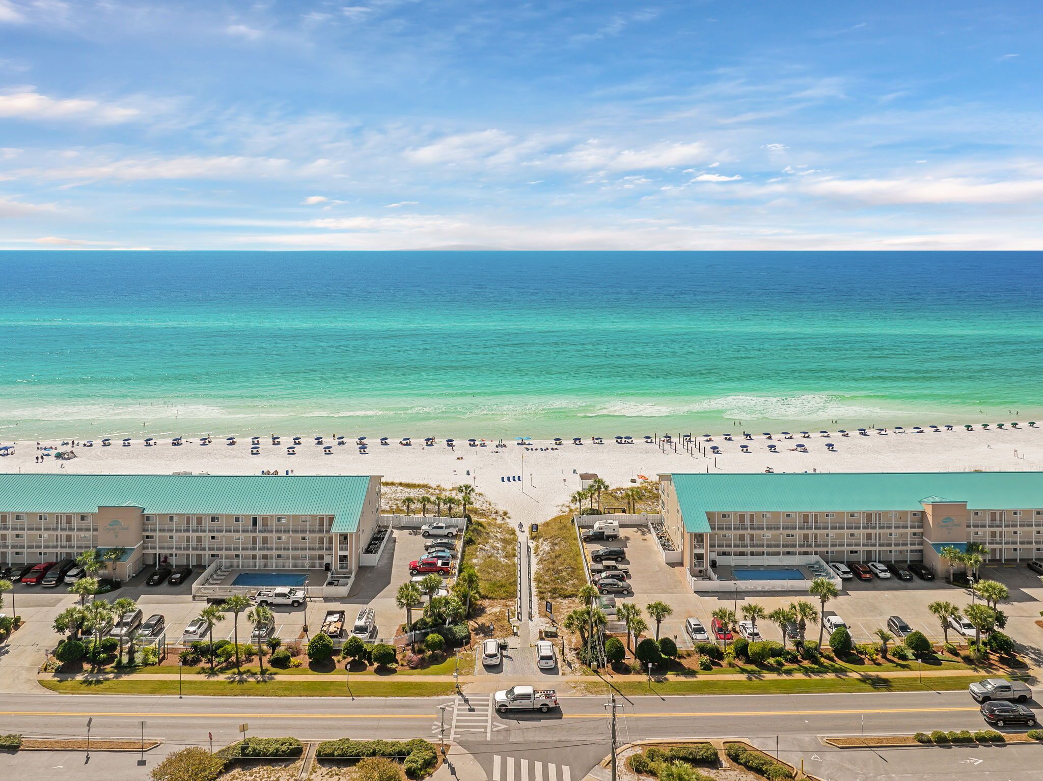 A hotel with a beach view, parking, and a pool.