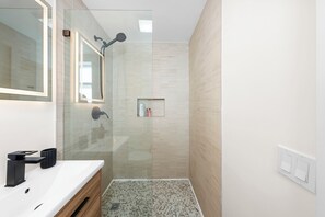 A modern bathroom with a glass shower enclosure, a white sink, and a mirror. - Chic Sobe Retreat 2-bedroom 2 full bath apartment walk to Lincoln Rd & Bay (Miami Beach)