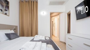 Una habitación de hotel con cama, televisión, baño y armario.