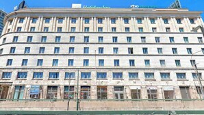 Un hotel de varios pisos con una fila de ventanas en cada planta, un letrero de farmacia y el letrero de Holiday Inn en la parte superior.