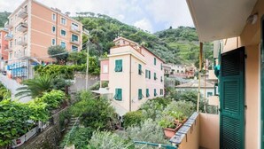 A residential building with a balcony, surrounded by greenery and other buildings. - Beach 7M| 1BR| Wifi| Nervi Park By Tilo (Genova)