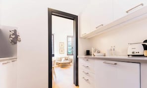 Eine moderne Küche mit weißen Schränken, einer Kaffeemaschine und einem Toaster.