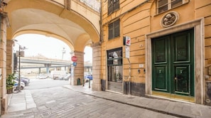 A street with a green door, a stop sign, and a building with a sign that says 'WORKSHOP'. - Aquarium 1'| 3BR| A/C|Parking| City Center By TILO (Genova)