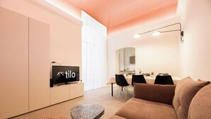 A modern living room with a TV, a dining area, and a sofa. - Aquarium 1'| 3BR| A/C|Parking| City Center By TILO (Genova)