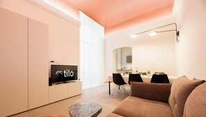 A modern living room with a TV, a dining area, and a sofa. - Aquarium 1'| 3BR| A/C|Parking| City Center By TILO (Genova)