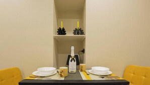 Une table à manger avec de l’assiette blanche, une bouteille de champagne et un chandelier.