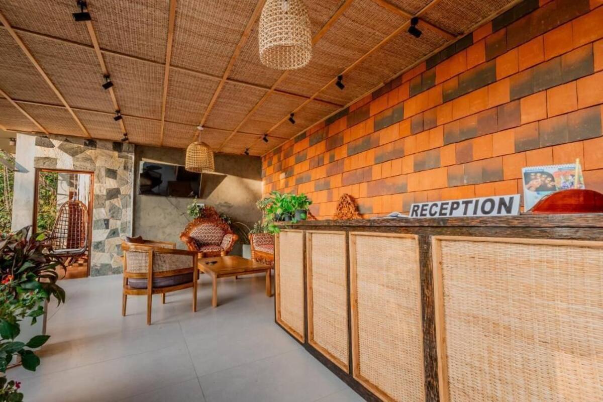 A reception area with a sign, wicker furniture, and a stone wall.