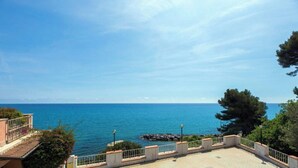Blick auf das Meer vom Balkon mit Geländer, ein klarer Himmel und der Ozean im Hintergrund.