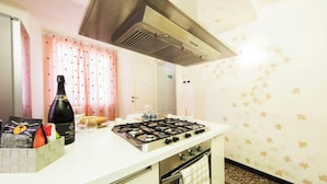Una cucina con piano cottura a gas, una bottiglia di vino e un sacchetto di snack sul bancone.