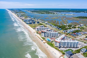 Ein Küstenort mit Strandhotels, einem Sandstrand und einer Marina.