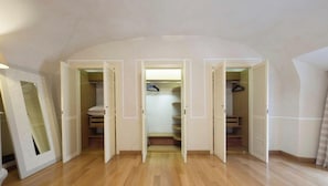 Ein Zimmer mit Holzboden, einem Schrank mit Schiebetüren und einem Spiegel an der Wand.