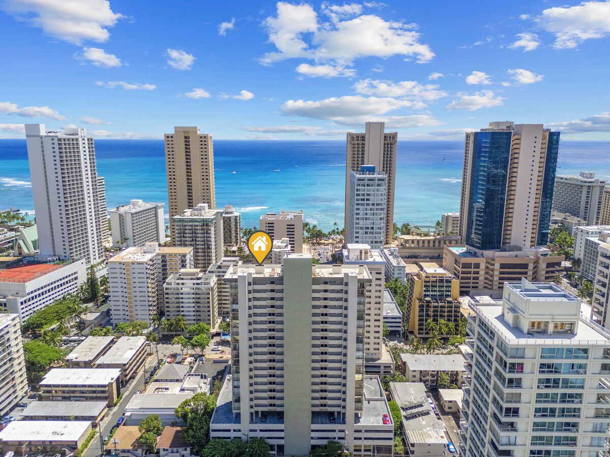 Eine Skyline mit Hochhäusern, wolkenlosem, blauem Himmel und dem Meer im Hintergrund.