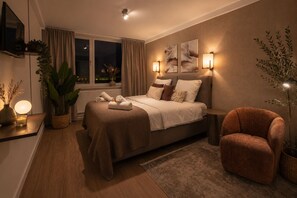 Une chambre moderne avec un lit, des tables de chevet, une chaise et une fenêtre avec des rideaux.