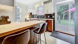 Une cuisine moderne dotée d’un bar, de grandes fenêtres et offrant une vue sur l’extérieur.