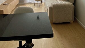 Ett modernt vardagsrum med en soffa, ett matbord och en tv som är monterad på väggen.