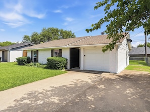 A single-story house with a garage, a front porch, and a well-maintained lawn. - Santa Clara | Large Backyard+ 2 Queen Beds (Frisco)