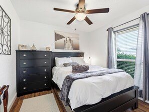 A bedroom with a bed, a dresser, a ceiling fan, a window with curtains, and a wall-mounted artwork. - Santa Clara | Large Backyard+ 2 Queen Beds (Frisco)
