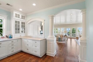 A spacious kitchen with white cabinetry, a large island, and a view to the dining area. - Harbor Cottage: 4  BR, 3.5  BA Cottage in Harbor Springs , Sleeps 12 (Harbor Springs)