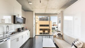 A modern kitchen with a built-in microwave, a large window, and a view of the cityscape. - Boulevard Stays Highrise STU Sky Pool, Parking, Gym 35 (Phoenix)