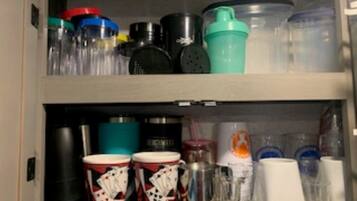 A storage cabinet with various containers and kitchenware.