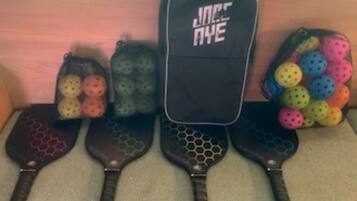 A row of black and colorful paddleboards with a black case labeled 'JACK AYE' in the center.
