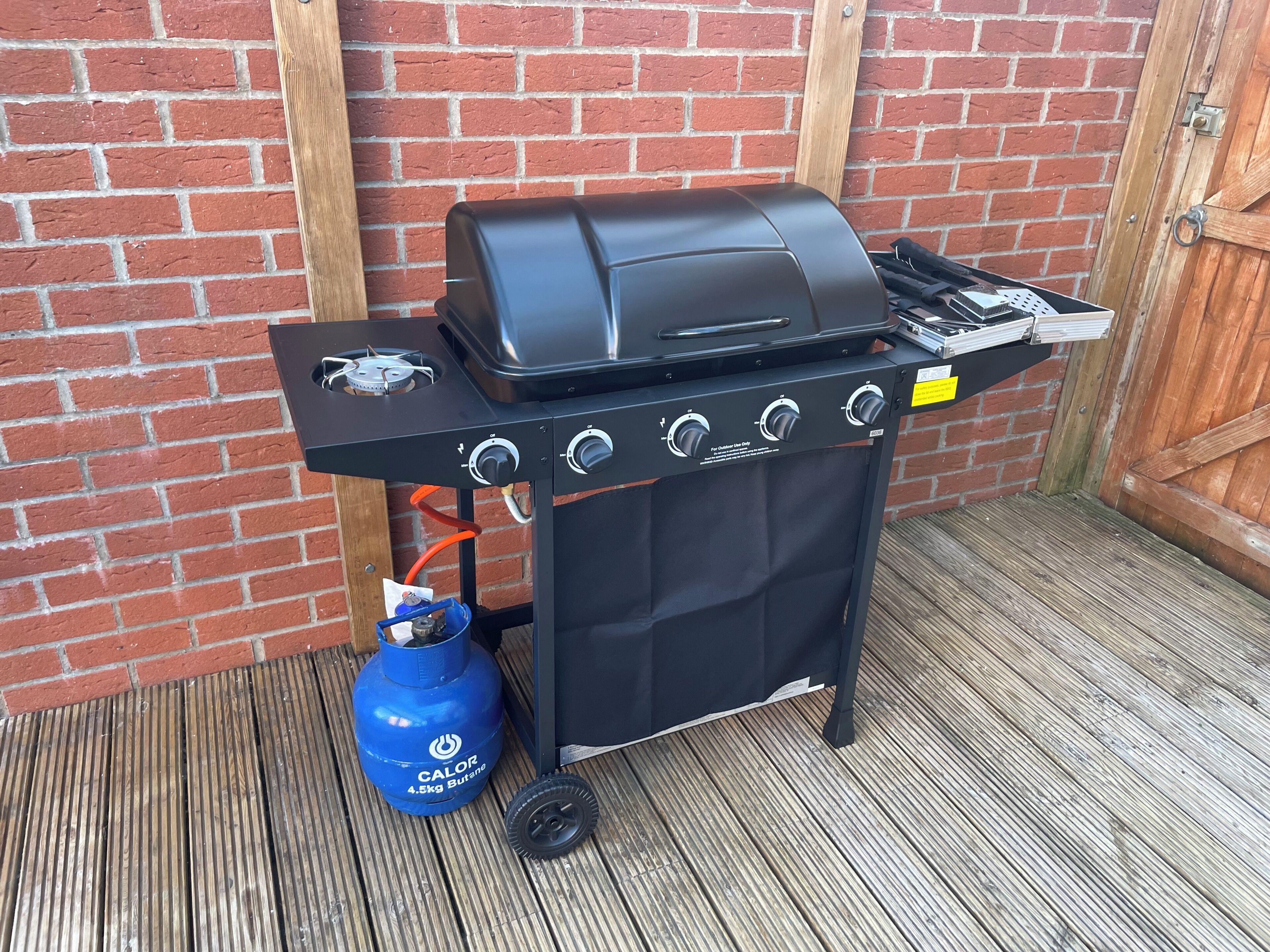 Ein tragbarer Grill mit Gasflasche und Propangasbehälter.