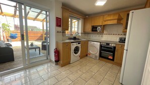 A kitchen with a washing machine, oven, microwave, and a refrigerator. - Tranquil Home Retreat (Berinsfield)