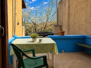 A small outdoor patio with a table, chairs, and a potted plant. - Cozy Stay in Chios Near the Beach Private Balcony (Chios)