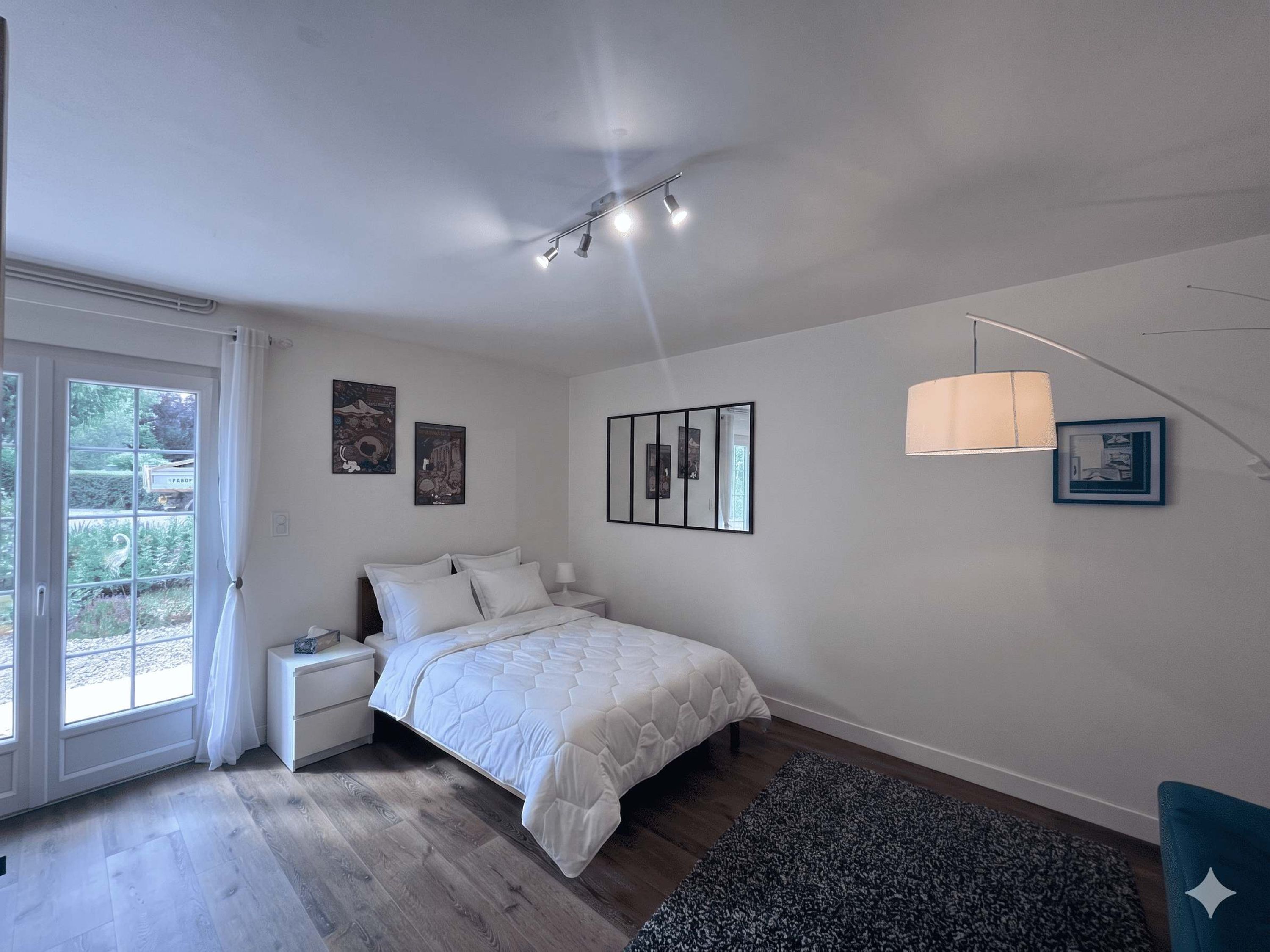 A bedroom with a bed, bedside tables, a window, and a ceiling light fixture.