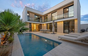 A modern two-story house with a swimming pool, outdoor seating, and a balcony. - Stunning home in Tribunj (Tribunj)