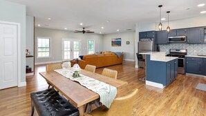 A spacious living area with a dining table, sofa, and kitchen area with modern appliances. - Dog Friendly, Beautiful Views, Hot tub! (Rileyville)