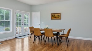 A dining area with a wooden table, four chairs, a lamp, and a framed picture on the wall. - Dog Friendly, Beautiful Views, Hot tub! (Rileyville)